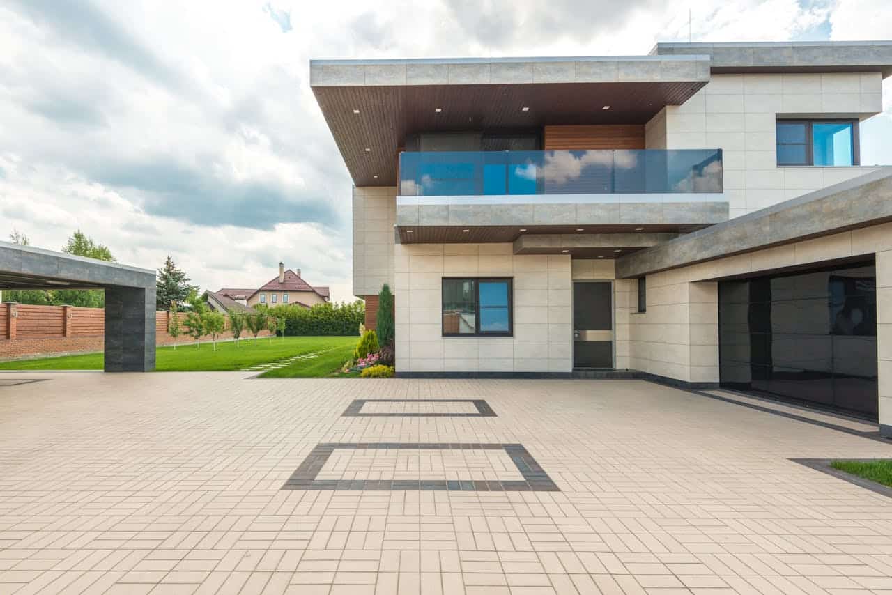 A modern house exterior with a spacious driveway and landscaped garden.