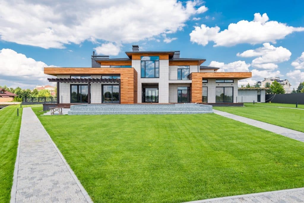 Front view of a modern luxury house with large windows and wooden accents.