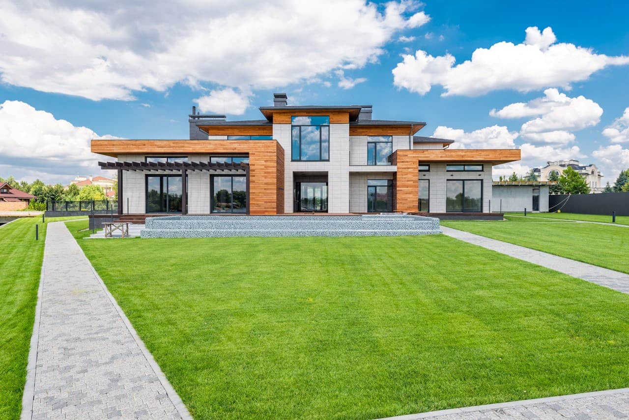 Front view of a modern luxury house with large windows and wooden accents.