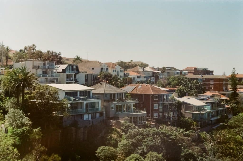 A picturesque view of coastal homes with palm trees and greenery.