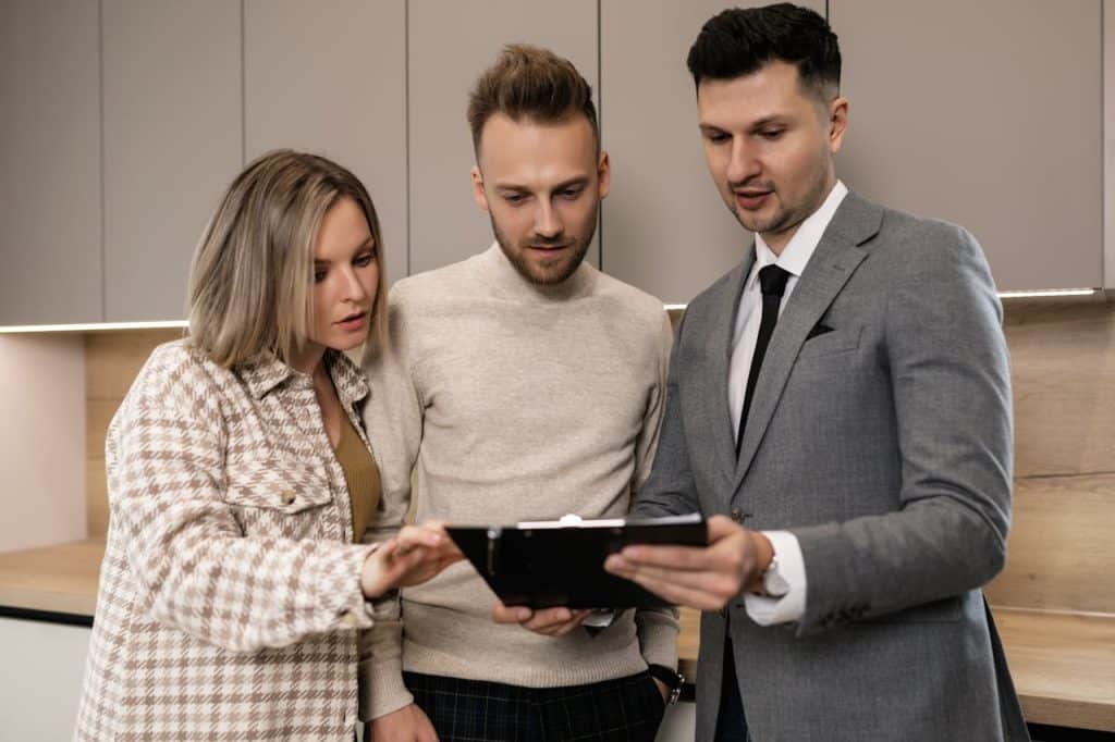 A team of three people discussing a project while looking at a tablet.