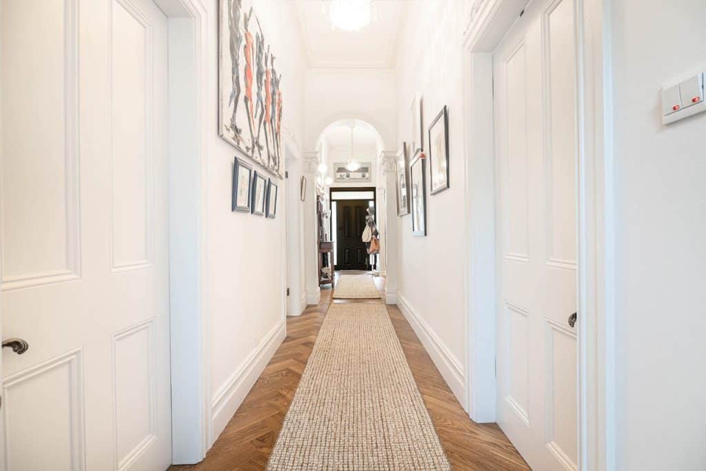 A stylish hallway featuring artwork and a cozy runner rug.