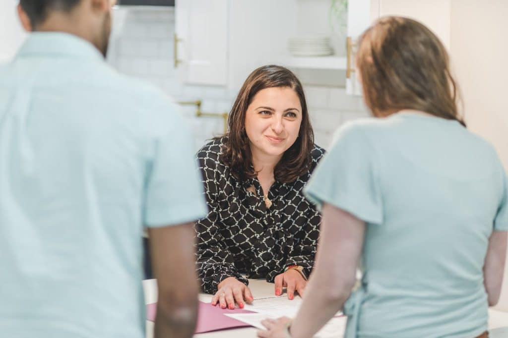An interactive office meeting with a woman presenting ideas to her colleagues.