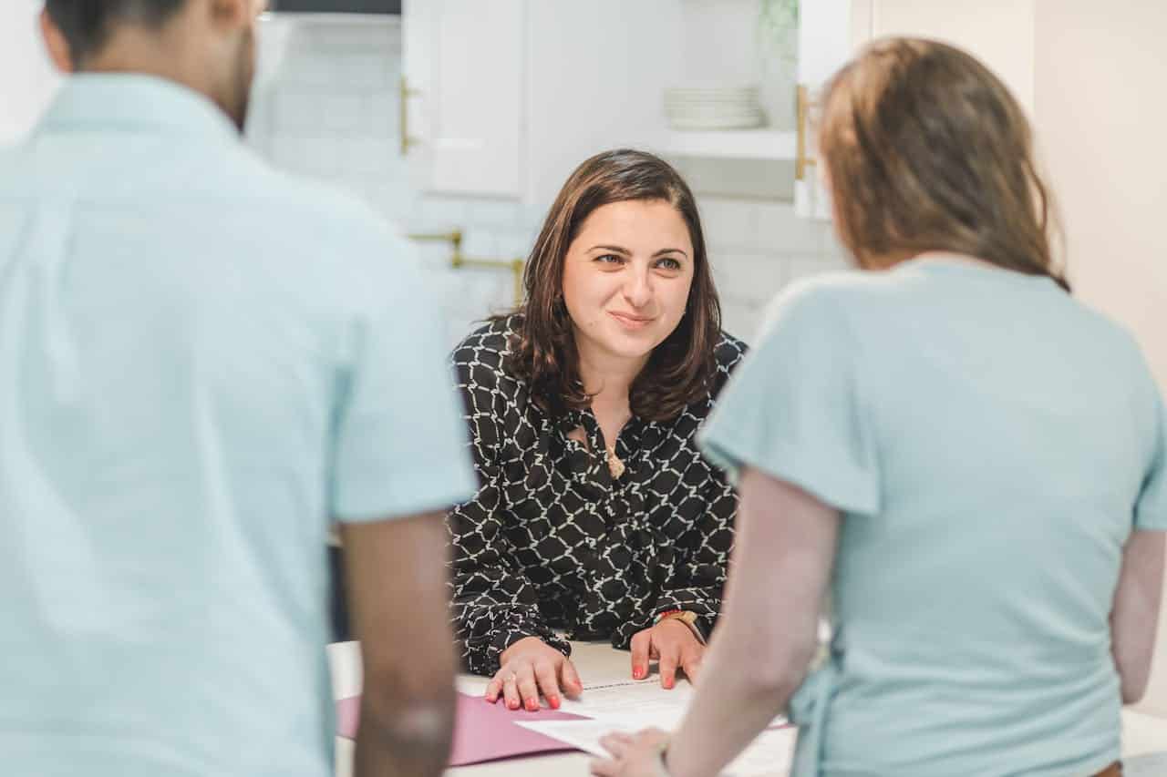 An interactive office meeting with a woman presenting ideas to her colleagues.