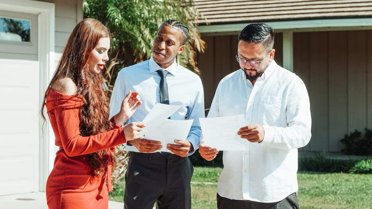 Group discussing real estate documents outdoors