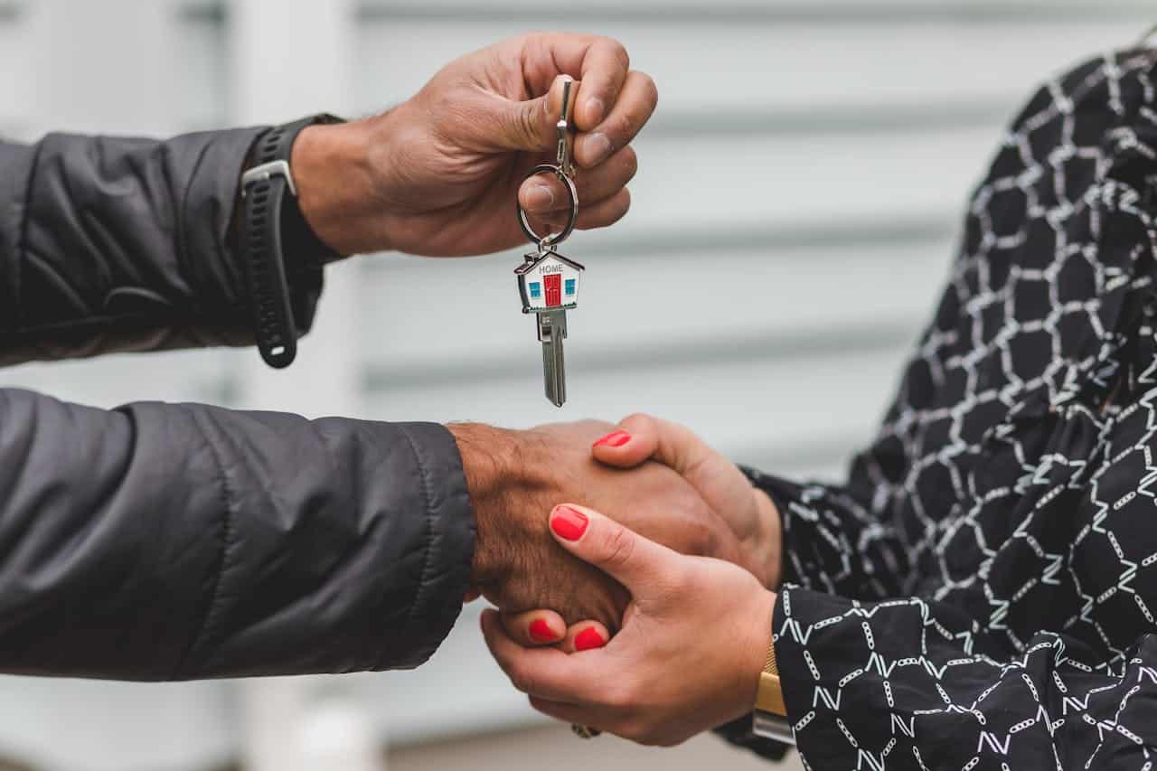 Close-up of a handshake while handing over a house key.