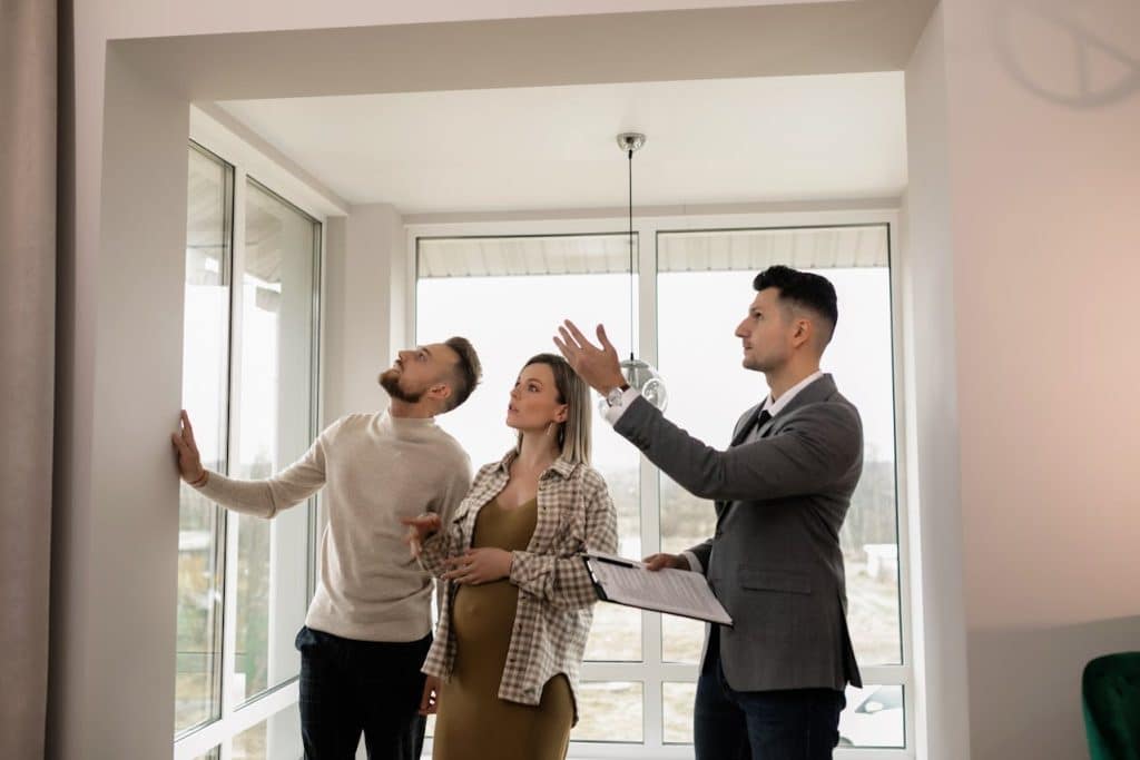 A real estate agent explaining features to a couple during a property tour.