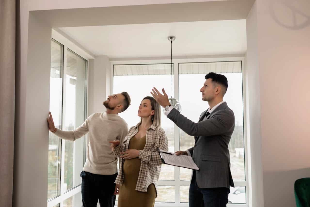 A real estate agent explaining features to a couple during a property tour.