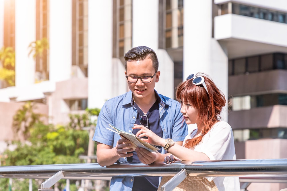 A young couple discussing plans outdoors in a modern urban setting.