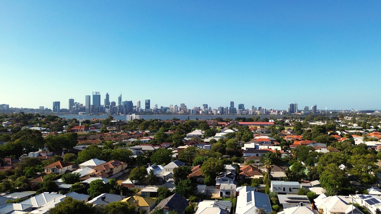Aerial view of Perth skyline with residential areas in the foreground.